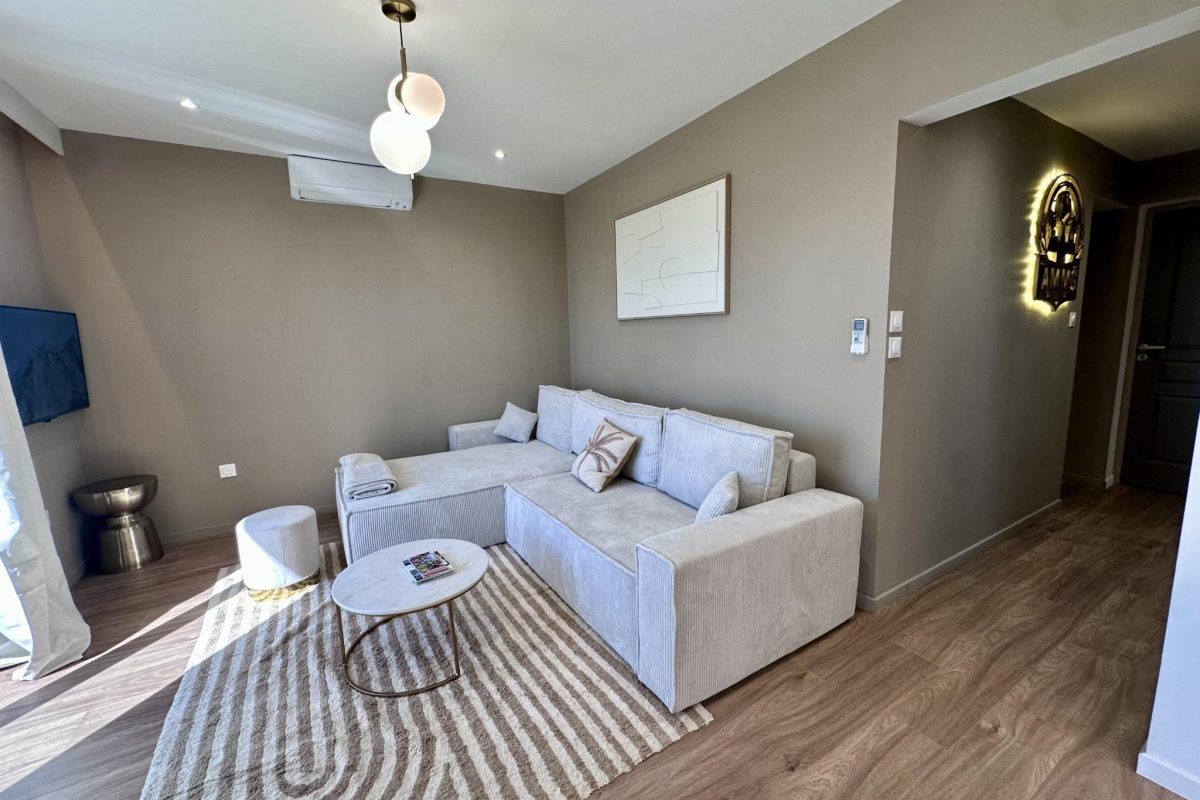 AMMG TOUR MARINA - Suite Impériale 1 Salon confortable de la suite impériale à Calais avec canapé en velours et éclairage moderne.